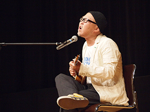 ミュージシャンの久保田さんが学生たちを歌で激励